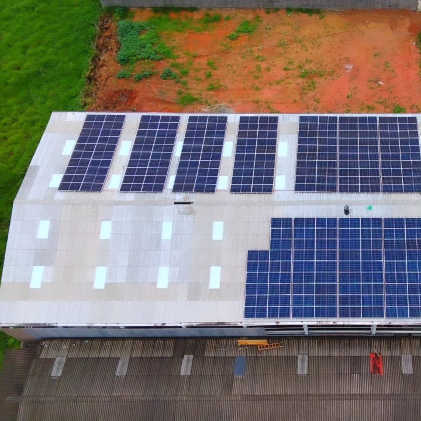 Grande cobertura de galpão com vários conjuntos de painéis solares instalados