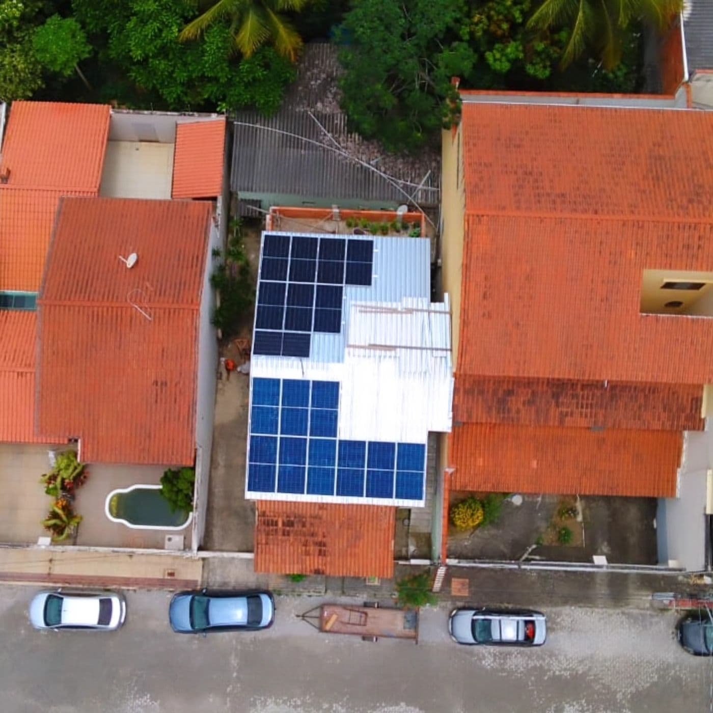 Vista aérea de casa com painéis solares em cobertura metálica branca
