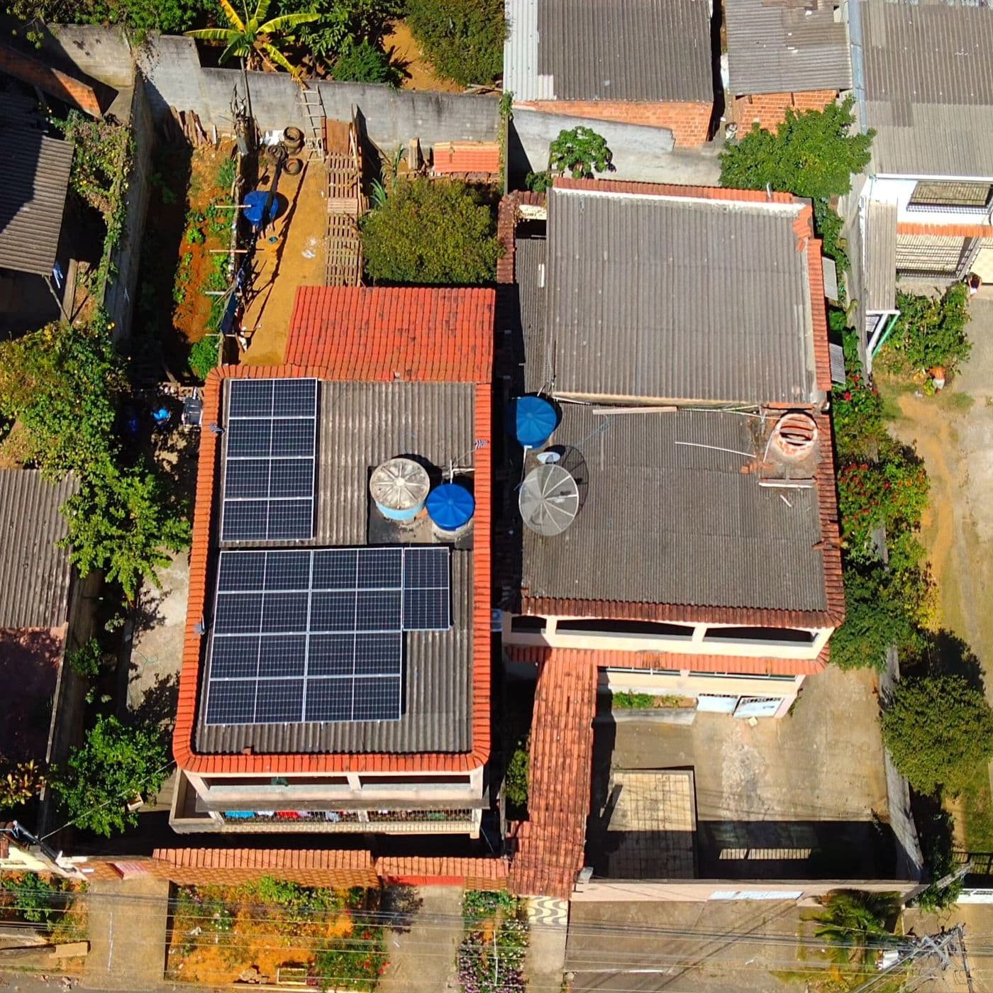 Vista aérea de sobrado com painéis solares no telhado de telhas cerâmicas